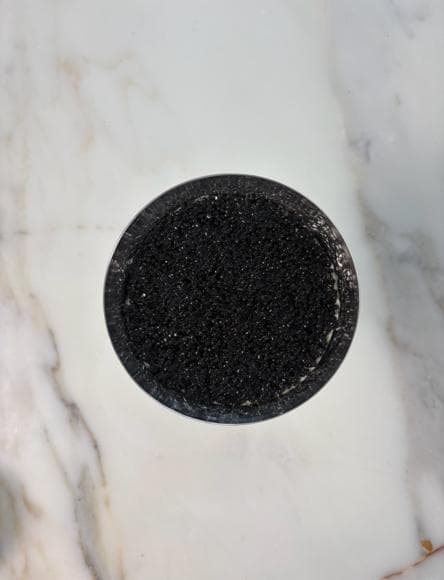 A round tiramisu covered entirely with an even layer of black caviar